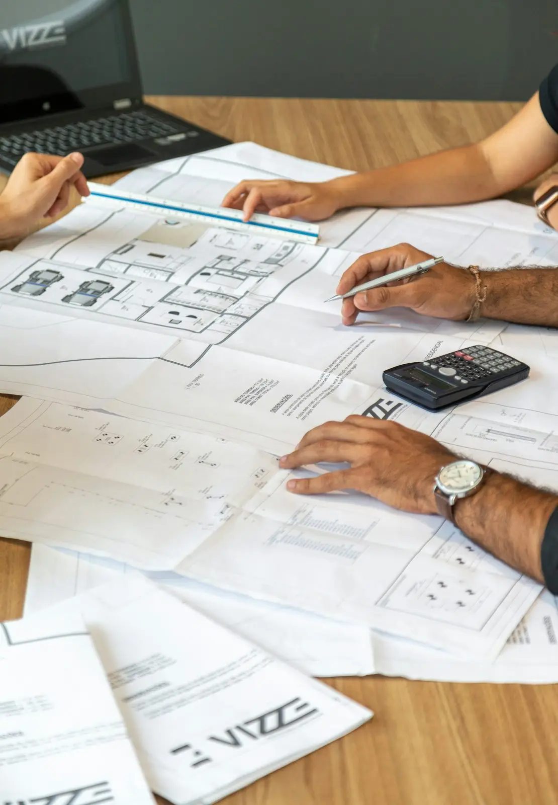 Plans de construction étalés sur une table pendant une discussion de projet